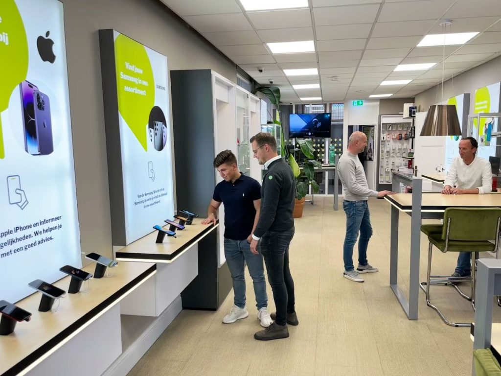 Een medewerker van Audiocom helpt een klant in de winkel in Dokkum